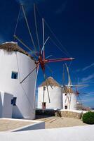 molinos de viento griegos tradicionales en la isla de mykonos al amanecer, cícladas, grecia foto