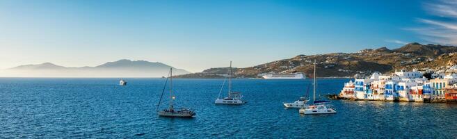 Sunset in Mykonos, Greece, with cruise ship and yachts in the harbor photo