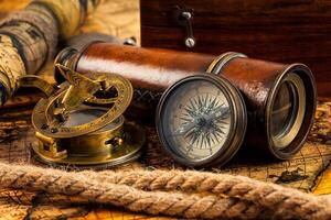 Old vintage compass and navigation instruments on ancient map photo