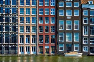 houses and boat on Amsterdam canal Damrak with reflection. Ams photo