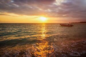 Calm ocean with boat on sunrise photo