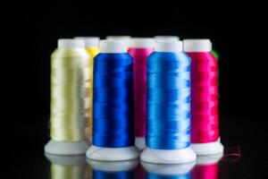 set of different color sewing threads,on black background. photo