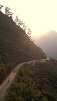 aéreo ver de motocicleta montando a lo largo montaña la carretera a atardecer, Vietnam video