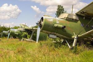 Old abandoned airfield with abandoned planes on the grass photo