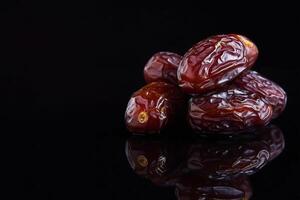 AI generated Juicy dates on a black reflective background photo