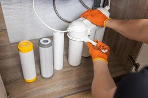 Plumber installs or change water filter. Replacement aqua filter. photo