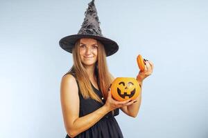 Happy young woman in halloween witch costume with pumpkin basket jack-o-lantern photo