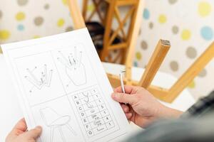 Self-assembly furniture concept. The young man himself assembling chairs photo