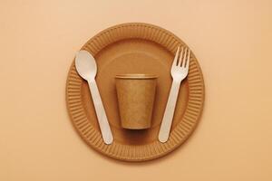 A set of disposable tableware on a brown background photo