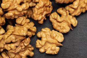 Walnuts. Walnut kernels on dark black stone background. Top view, flat lay photo