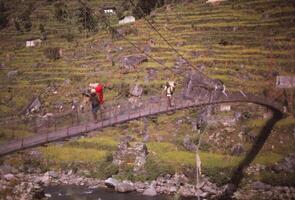 Hiker on narrow suspension bridge photo