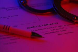 District Court Criminal complaint court papers with handcuffs and blue pen on table photo