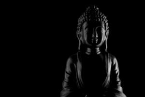 Buda purnima y vesak día concepto, gris Buda estatua con bajo llave ligero en contra profundo negro antecedentes foto