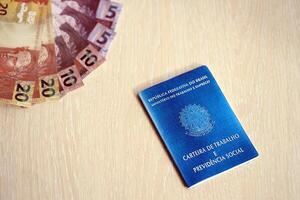 Brazilian work card and social security blue book and reais money bills photo