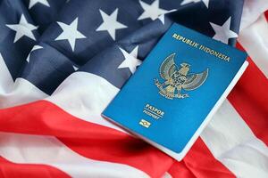 Blue Republic Indonesia passport on United States national flag background close up photo