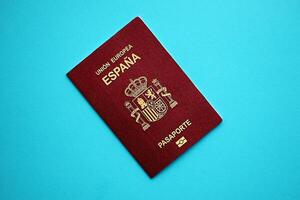 Red Spanish passport of European Union on blue background close up photo