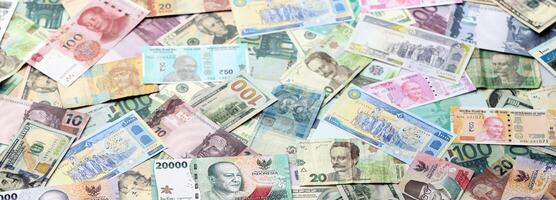 Many banknotes of different currency. Background of big amount of random money bills photo