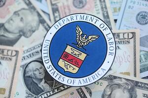 KYIV, UKRAINE - MARCH 9, 2024 US Department of Labor seal on many US dollar bills photo