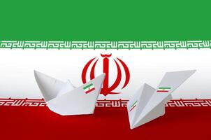 Iran flag depicted on paper origami airplane and boat. Handmade arts concept photo