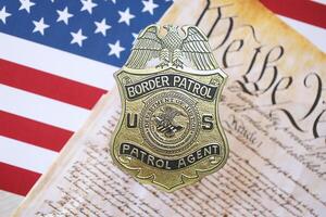 KYIV, UKRAINE - MARCH 9, 2024 US Border Patrol Agent badge with United States Constitution on flag photo