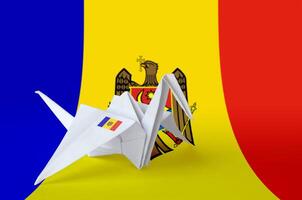 Moldova flag depicted on paper origami crane wing. Handmade arts concept photo