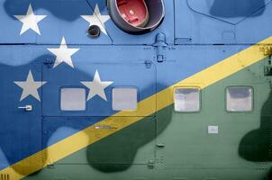 Solomon Islands flag depicted on side part of military armored helicopter closeup. Army forces aircraft conceptual background photo