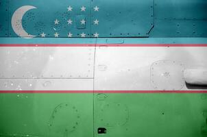 Uzbekistan flag depicted on side part of military armored helicopter closeup. Army forces aircraft conceptual background photo