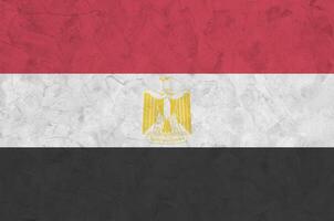 Egypt flag depicted in bright paint colors on old relief plastering wall. Textured banner on rough background photo