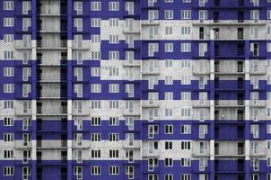 Greece flag depicted in paint colors on multi-storey residental building under construction. Textured banner on brick wall background photo