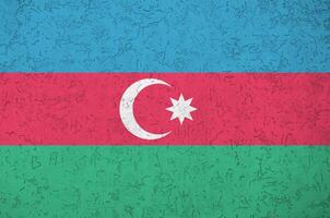 Azerbaijan flag depicted in bright paint colors on old relief plastering wall. Textured banner on rough background photo