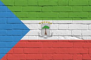 Equatorial Guinea flag depicted in paint colors on old brick wall. Textured banner on big brick wall masonry background photo