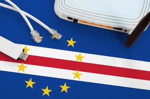 cabo verde bandera representado en mesa con Internet rj45 cable, inalámbrico USB Wifi adaptador y enrutador Internet conexión concepto foto