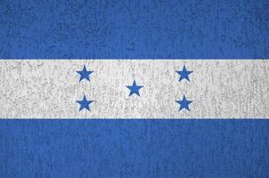 Honduras flag depicted in bright paint colors on old relief plastering wall. Textured banner on rough background photo