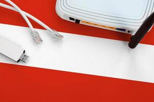 Austria flag depicted on table with internet rj45 cable, wireless usb wifi adapter and router. Internet connection concept photo