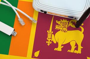 Sri Lanka flag depicted on table with internet rj45 cable, wireless usb wifi adapter and router. Internet connection concept photo