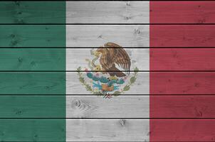 bandera de méxico representada en colores de pintura brillante en la pared de madera vieja. banner texturizado sobre fondo áspero foto