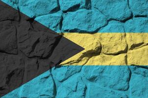 Bahamas flag depicted in paint colors on old stone wall closeup. Textured banner on rock wall background photo