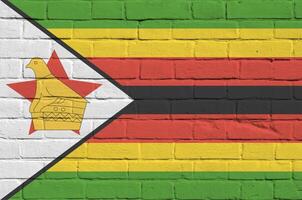 Zimbabue bandera representado en pintar colores en antiguo ladrillo pared. texturizado bandera en grande ladrillo pared albañilería antecedentes foto