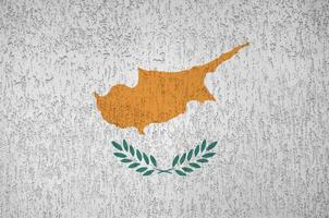 Cyprus flag depicted in bright paint colors on old relief plastering wall. Textured banner on rough background photo