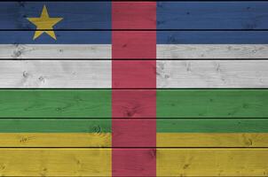 Central African Republic flag depicted in bright paint colors on old wooden wall. Textured banner on rough background photo