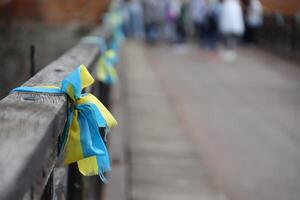 Ribbons in the colors of the national flag of Ukraine are tied to the handrail photo