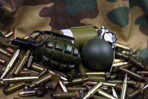 Different types of ammunition on a camouflage background. Preparing for war photo