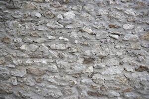 Very old brick stone wall of castle or fortress of 18th century. Full frame wall with obsolete dirty and cracked bricks photo