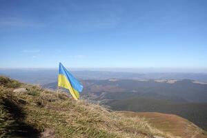 Ukrainian flag on top of Hoverla mountain in Ukraine photo