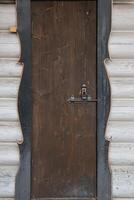 Old wooden door with metal locker and black framing texture photo