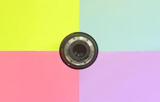 minimalismo con lente fotográfica sobre fondo azul, violeta, rosa y amarillo foto