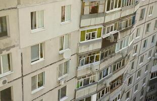 Facade of a grey multi storey soviet panel building. Russian old urban residential houses with windows and balcony. Russian neighborhood photo