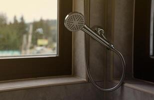 Silvery shower in modern hotel bathroom with natural light photo