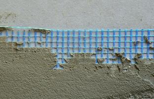 la textura de la pared, cubierta con placas de poliestireno expandido gris, recubiertas con una malla de refuerzo azul y cubiertas con una mezcla para encolar. etapa de aislamiento de la pared foto