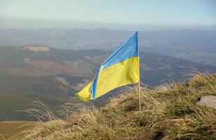 Ukrainian flag on top of Hoverla mountain in Ukraine photo